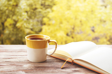 Cup of tea with notepad on the wood background