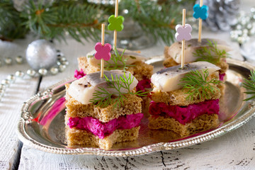 Canapes in the form of a star with pickled herring, beetroot and