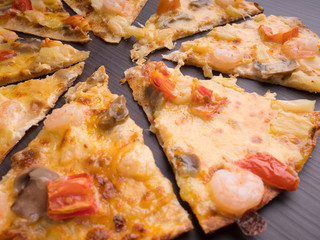 shrimp cocktail pizza with tomato and pineapple on brown wood table
