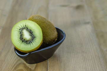 kiwi fruit and half with black bowl