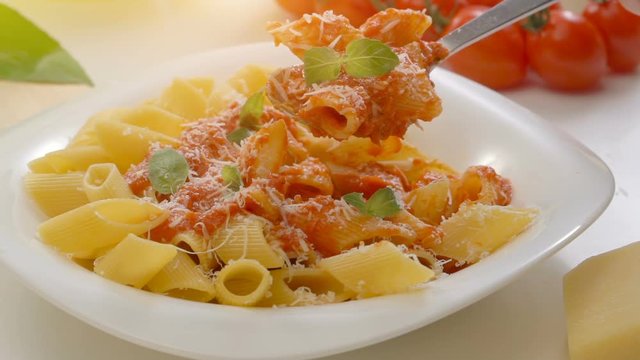 Hot Pasta with tomato Sauce, Parmesan Cheese and Basil on a Spoon