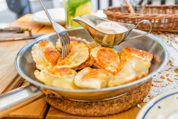 Homemade polish pierogis with sour cream and parsley