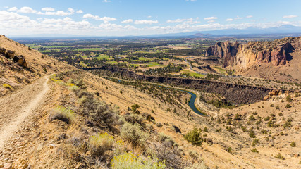 The road among the dry grass. The beautiful landscape of cliffs. Smith Rock state park, Oregon