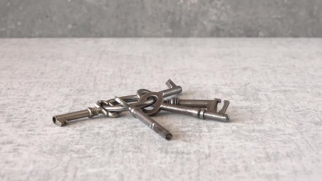 Keyring with old house keys on stone table sliding in