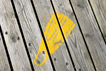 Yellow swim fin painted footprint on Southwold Pier, UK - obrazy, fototapety, plakaty