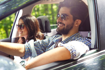 Portrait of young couple driving a car.