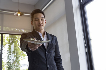 Young businessman sitting at a desk in the office. Counting mone