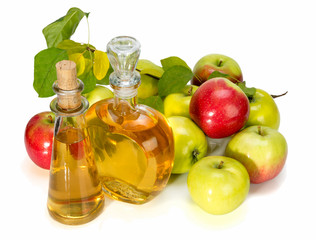 apple cider vinegar in a glass vessel and red and green apples