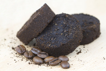 Used coffee grounds after espresso machine and coffee beans on wooden background