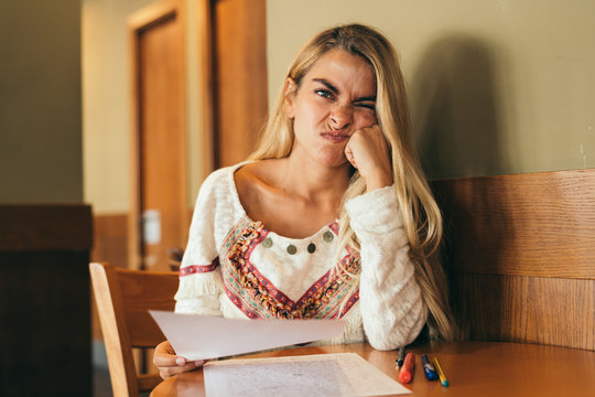 Bored young woman with notes at table
