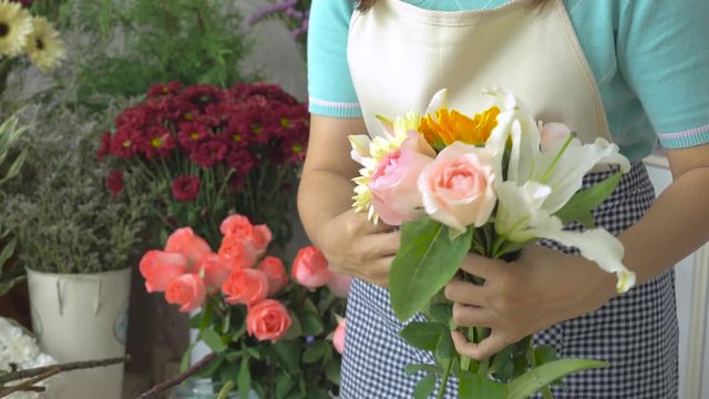 Florist woman arranging a beautiful flower bouquet with beautiful flowers, ungraded tone  