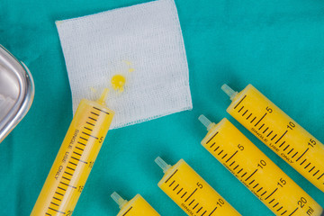 fat in syringes for fat grafting on sterile green fabric