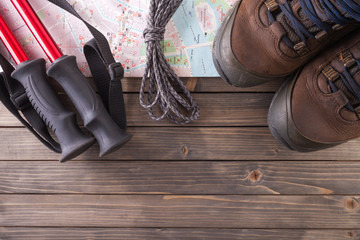 Equipment for hiking on a wooden floor background.