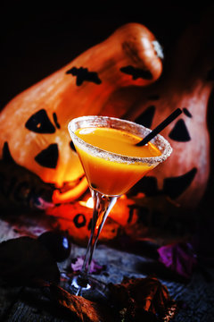Halloween cocktail, pumpkin orange drink with spices. Dark vinta