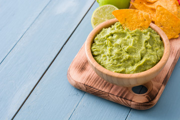 Nachos and guacamole on blue wooden table

