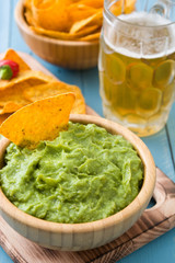 Nachos, guacamole and beer on blue wooden table

