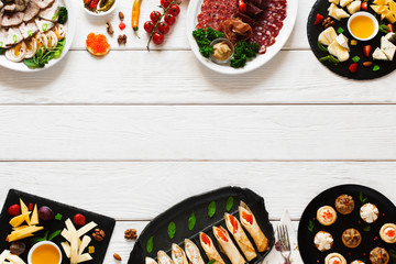 Tasty appetizing luxury snacks on white wooden background, flat lay, copy space. Cuisine, menu, banquet concept