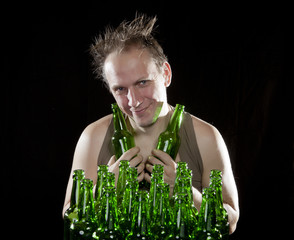 The happy tipsy man near empty beer bottles