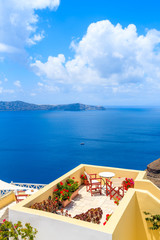 Fototapeta premium Chairs and table on terrace with sea view in beautiful Firostefani village, Santorini island, Greece