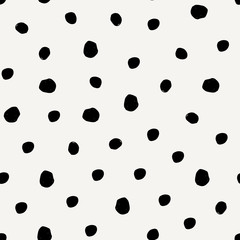 Seamless pattern with hand drawn dots in black on cream background.