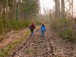 boy and girl, walking or hiking in autumn forest, back view.