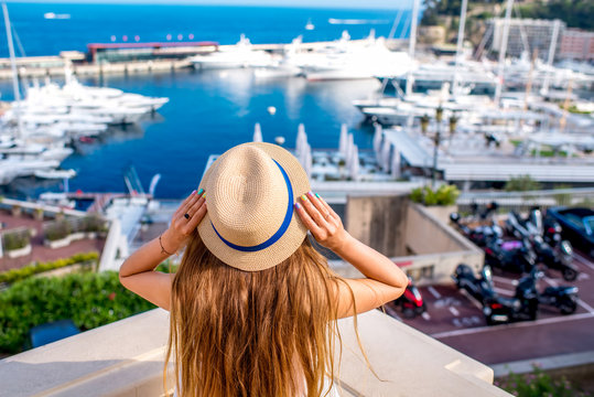 Young female traveler enjoying great view on the harbor with yachts in Monte Carlo in Monaco