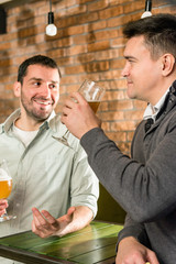 Male friends having beer and gossiping