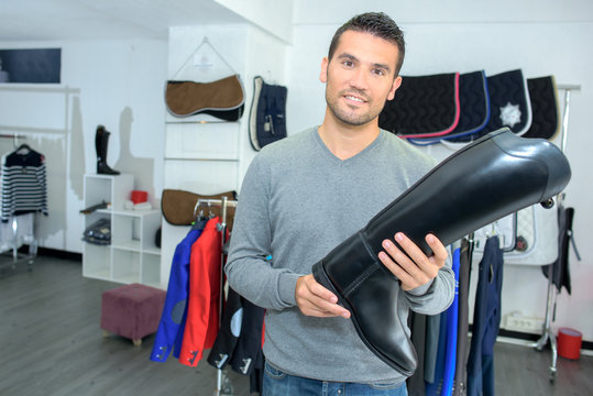 Man In Equestrian Store Holding Riding Boot