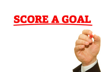 Businessman hand writing SCORE A GOAL message on a transparent wipe board.