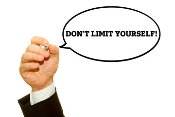 Businessman hand writing DON'T LIMIT YOURSELF message on a transparent wipe board.