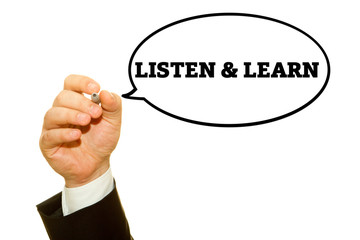 Businessman hand writing LISTEN AND LEARN message on a transparent wipe board.