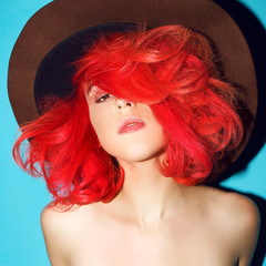 Sensual girl in hat and bright red hair