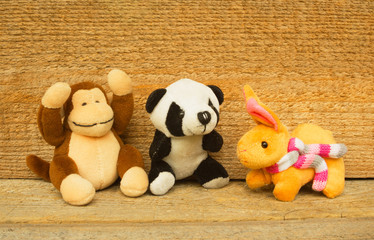 Set of soft toys. Children's toys made of artificial fur, fabric and stuffing material. Children's toys on the wooden background
