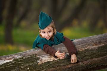 A young boy dressed up as Robin Hood playing in the forest