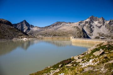 Naklejka na ściany i meble Venerocolo lake and its dam at the foot of Adamello mountain