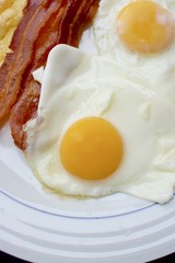 Cooked breakfast with eggs, streaky bacon and grilled cheese
