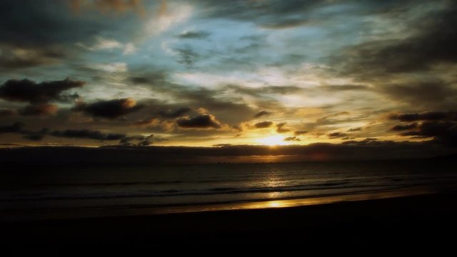 A saturated sunset at a California beach with sky,clouds and reflections. HD 1080.