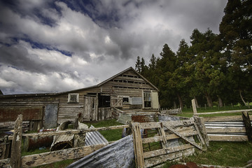 
Old dilapidated shearing shed against a dynamic cloudy blue sky background
