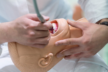 Male dental student practicing on doll.