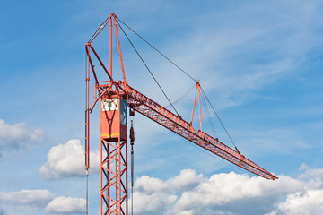 Fototapeta na wymiar Small construction crane and the cloudy sky