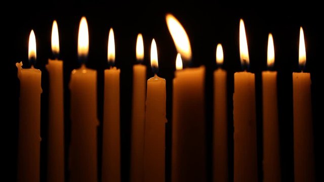 Several candles grouped together isolated on a black background. HD 1080.