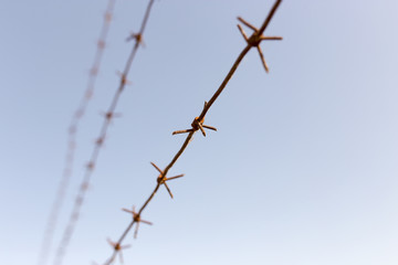 Barbed wire against the blue sky