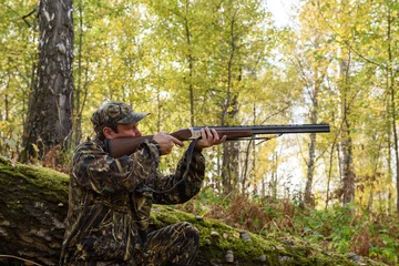 Photo sur Plexiglas Chasser Chasseur avec une arme à feu dans les bois d& 39 automne, chassant un tétras noisette