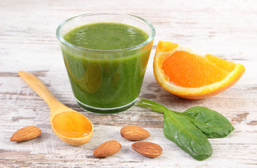 Ingredients and fresh cocktail from spinach on wooden background, healthy nutrition