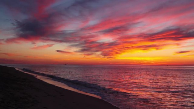 Lonely boat at sea and dramatic sunset on the empty beach, Rhode Island, USA