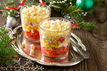 Christmas salad with tomatoes, corn and crackers on a wooden tab