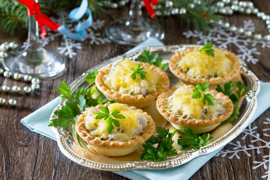 Holiday appetizer: tartlets with mushrooms and meat on a celebra