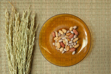 Fototapeta na wymiar Top view of Peanut in plate on the bamboo mats background