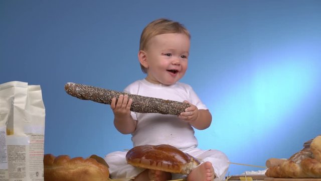 baby baker playing with pasta and bread