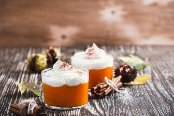 Homemade autumn dessert of pumpkin mousse with whipped cream